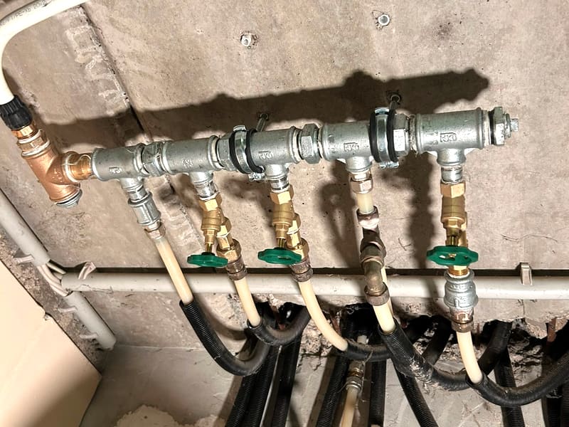 Neuer verzinkter Wasserverteiler mit neuen Absperrventilen an derselben Wandstelle.